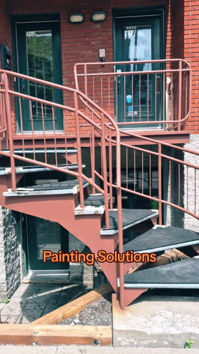 Chantier extérieur de Painting Solutions : escalier et garde-corps devant une façade de brique.